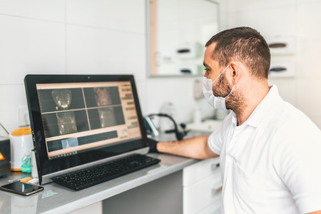 Dentist making examination of the x-ray and choosing treatment in the clinicの写真素材