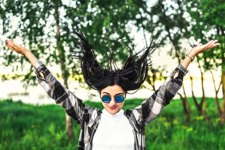 Happy pretty girl outdoor showing tongue and throw her hairの写真素材