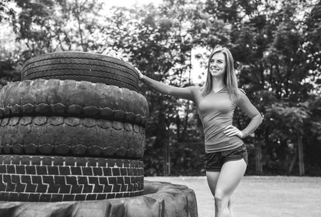 Young sporty girl workout outdoor with big tireの写真素材