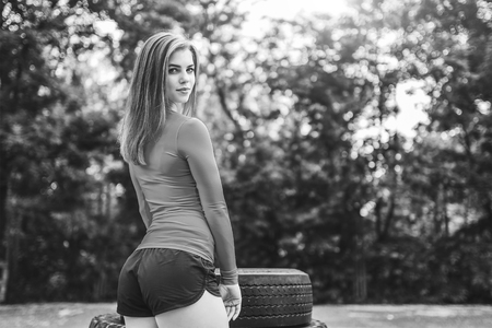 Young sporty girl workout outdoor with big tireの写真素材