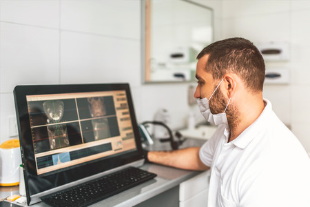 Dentist making examination of the x-ray and choosing treatment in the clinicの写真素材