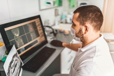 Dentist making examination of the x-ray and choosing treatment in the clinicの写真素材
