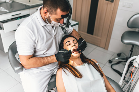 Dentist working in dental clinic with patient in the chairの写真素材