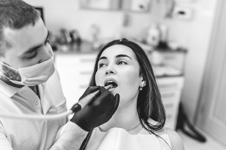 Dentist working in dental clinic with patient in the chairの写真素材