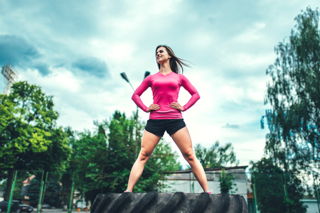 Young sporty girl workout outdoor with big tireの写真素材