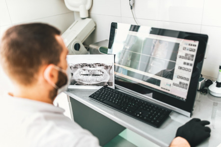 Dentist making examination of the x-ray and choosing treatment in the clinicの写真素材