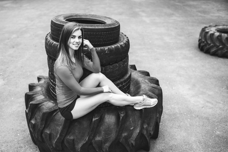 Young sporty girl workout outdoor with big tireの写真素材