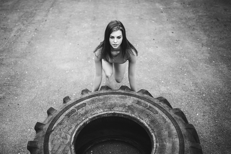 Young sporty girl workout outdoor with big tireの写真素材