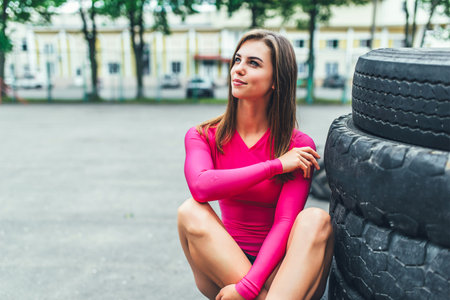 Young sporty girl workout outdoor with big tire