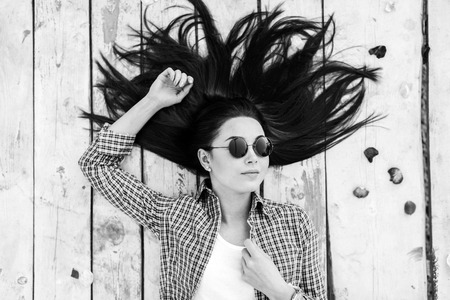 Brunette girl relaxing on wooden floor outdoorの写真素材
