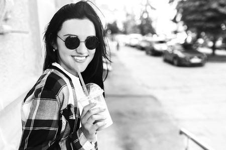 Pretty brunette girl drinking cold coffee outdoorの写真素材