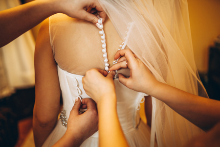 Beautiful bride dressing up before wedding ceremonyの写真素材
