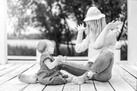 Happy mother with her little daughter playing outdoorの写真素材