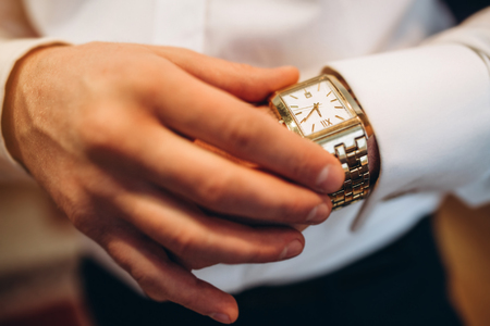 Male looking on the watch on his handの写真素材