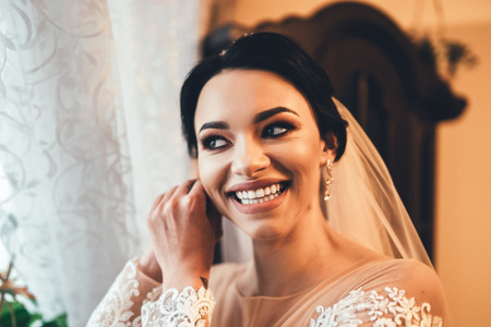 Pretty bride dressing up before wedding の写真素材