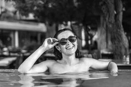 Pretty brunette girl sunbathing at the swimming poolの写真素材