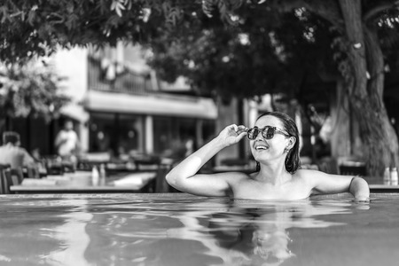 Pretty brunette girl sunbathing at the swimming poolの写真素材