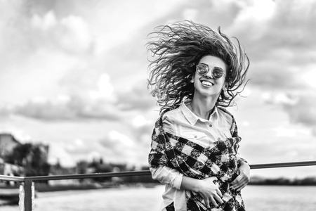 Pretty girl with curly hair near lakeの写真素材