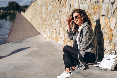 Pretty girl with curly hair relaxing outdoorの写真素材
