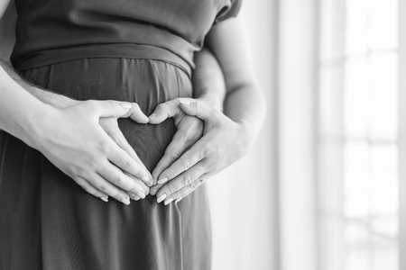 Pretty pregnant woman hug with her husbandの写真素材