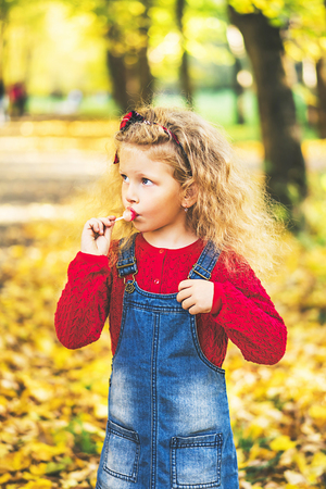 Pretty little girl have fun in the park, autumn timeの写真素材