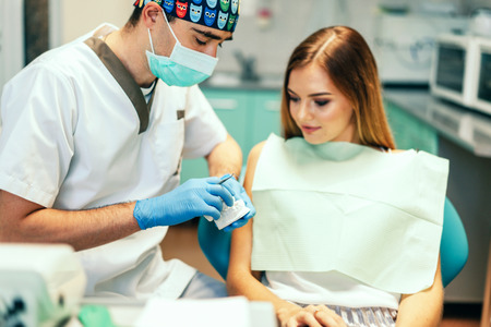 Dentist examine female patient with braces in denal officeの写真素材