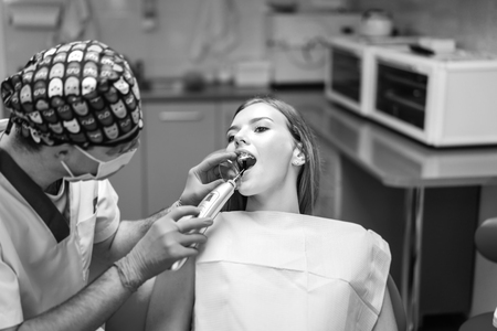 Dentist carries out treatment of the young girl with braces in dental officeの写真素材