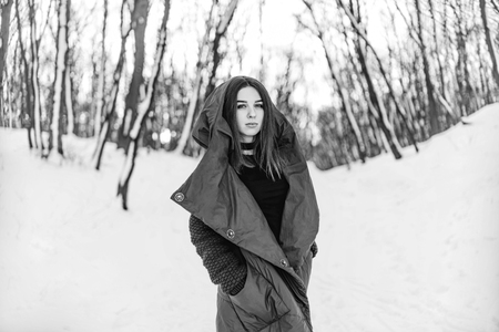 Pretty girl walking in the winter forestの写真素材