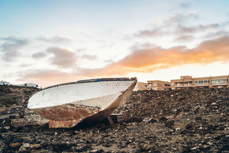 Old rusty boat with sunset sky behindの写真素材