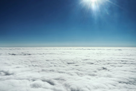 Clear view of the sky with clouds and sun from the plane