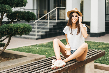 Brunette pretty tourist girl outdoor with cup of cold coffeeの写真素材