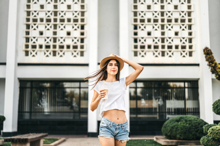 Brunette pretty tourist girl outdoor with cup of cold coffeeの写真素材