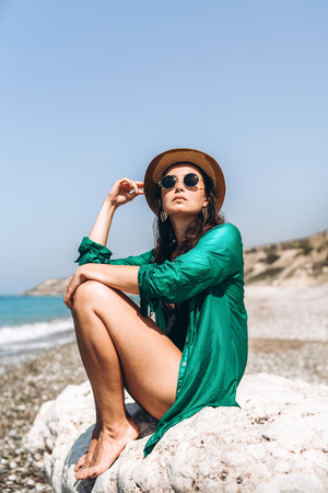 Pretty pan asian travel girl relaxing on the beach at the sea in green pareoの写真素材