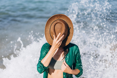 Girl in swimsuit relaxing on the beach near the sea in green pareo
