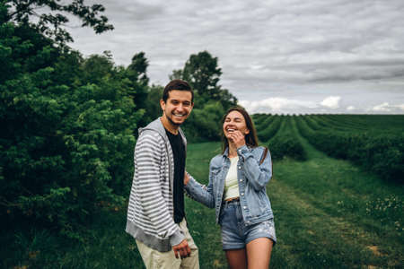 A tender loving couple walking in a field of currant. Man whirls woman in her arms. Love story.の写真素材