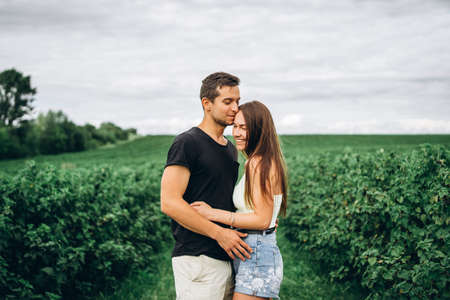A tender loving couple walking in a field of currant. Man whirls woman in her arms. Love story.の写真素材
