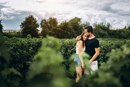 A tender loving couple walking in a field of currant. Man whirls woman in her arms. Love story.の写真素材