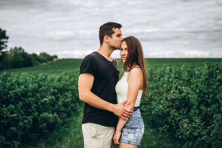 A tender loving couple walking in a field of currant. Man whirls woman in her arms. Love story.の写真素材