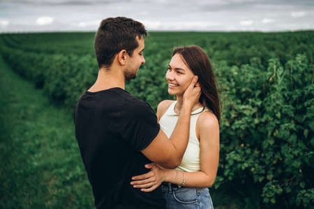 A tender loving couple walking in a field of currant. Man whirls woman in her arms. Love story.の写真素材
