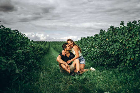 A tender loving couple walking in a field of currant. Man whirls woman in her arms. Love story.の写真素材