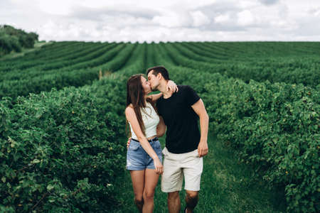 A tender loving couple walking in a field of currant. Man whirls woman in her arms. Love story.の写真素材