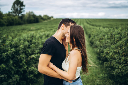 A tender loving couple walking in a field of currant. Man whirls woman in her arms. Love story.の写真素材