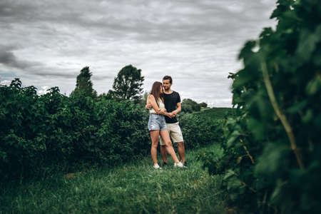 A tender loving couple walking in a field of currant. Man whirls woman in her arms. Love story.の写真素材