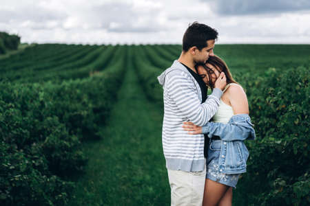 A tender loving couple walking in a field of currant. Man whirls woman in her arms. Love story.の写真素材