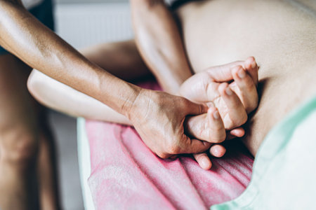 A woman physiotherapist doing massage for a man in the medical office. Closeup of hands doing...