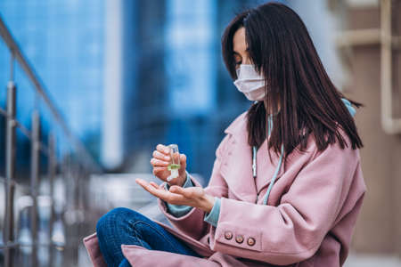 Female in medical mask outdoors in the empty city. Health protection and prevention of virus outbreak, coronavirus, COVID-19, epidemic, pandemic, infectious diseases, quarantine conceptの写真素材