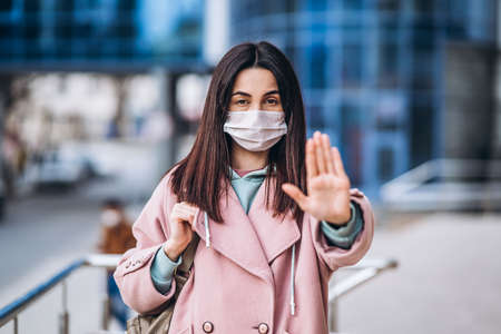 Female in medical mask outdoors in the empty city. Health protection and prevention of virus outbreak, coronavirus, COVID-19, epidemic, pandemic, infectious diseases, quarantine conceptの写真素材