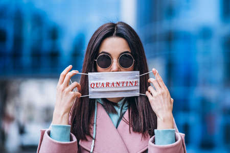 Female in medical mask outdoors in the empty city. Health protection and prevention of virus outbreak, coronavirus, COVID-19, epidemic, pandemic, infectious diseases, quarantine conceptの写真素材