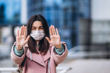 Female in medical mask outdoors in the empty city. Health protection and prevention of virus outbreak, coronavirus, COVID-19, epidemic, pandemic, infectious diseases, quarantine conceptの写真素材