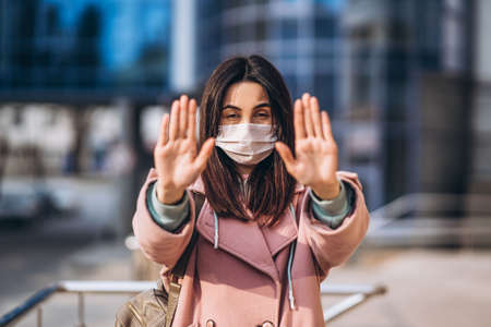 Female in medical mask outdoors in the empty city. Health protection and prevention of virus outbreak, coronavirus, COVID-19, epidemic, pandemic, infectious diseases, quarantine conceptの写真素材